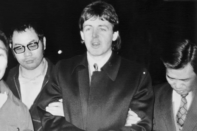 La imagen muestra a Paul McCartney siendo escoltado por dos policías en Tokio, Japón.